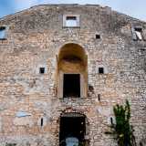 ...puntellata da feritoie medievali e da un finestrone centrale...